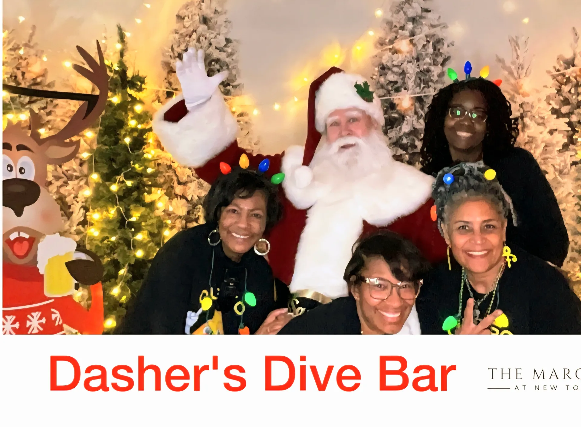 Santa Claus posing with four women in festive attire at Dasher's Dive Bar holiday event with Christmas decorations